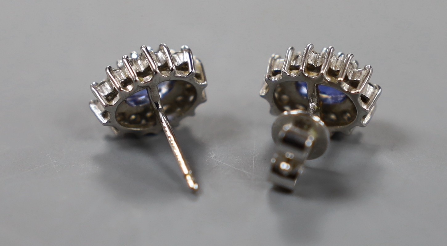 A modern pair of 750 white metal, sapphire and diamond set oval cluster earrings, length 10mm, gross weight 4.1 grams (one butterfly missing).